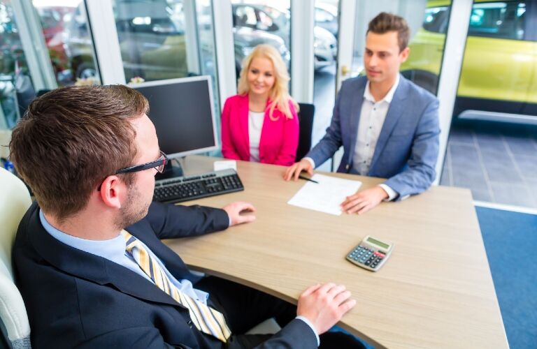 couple at the dealership doing paperwork couple at the dealership doing paperwork